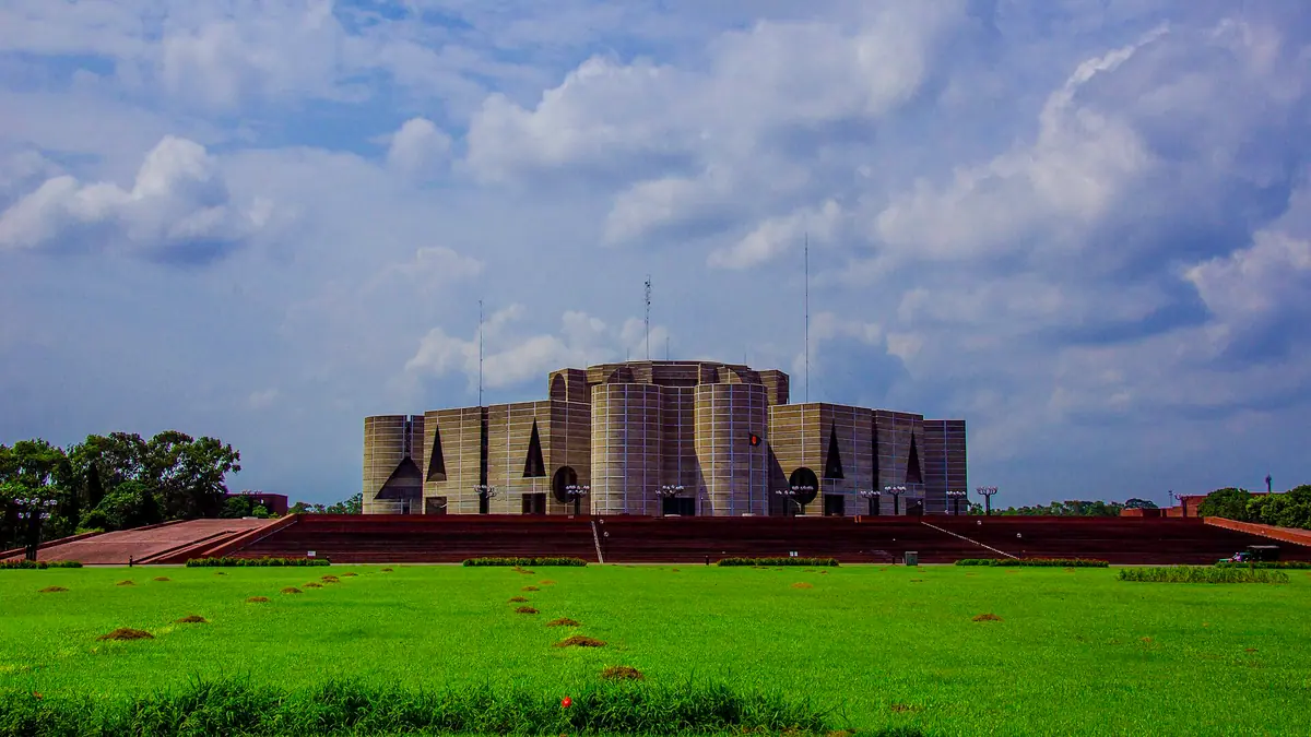 The National Parliament House in Dhaka under a cloudy sky